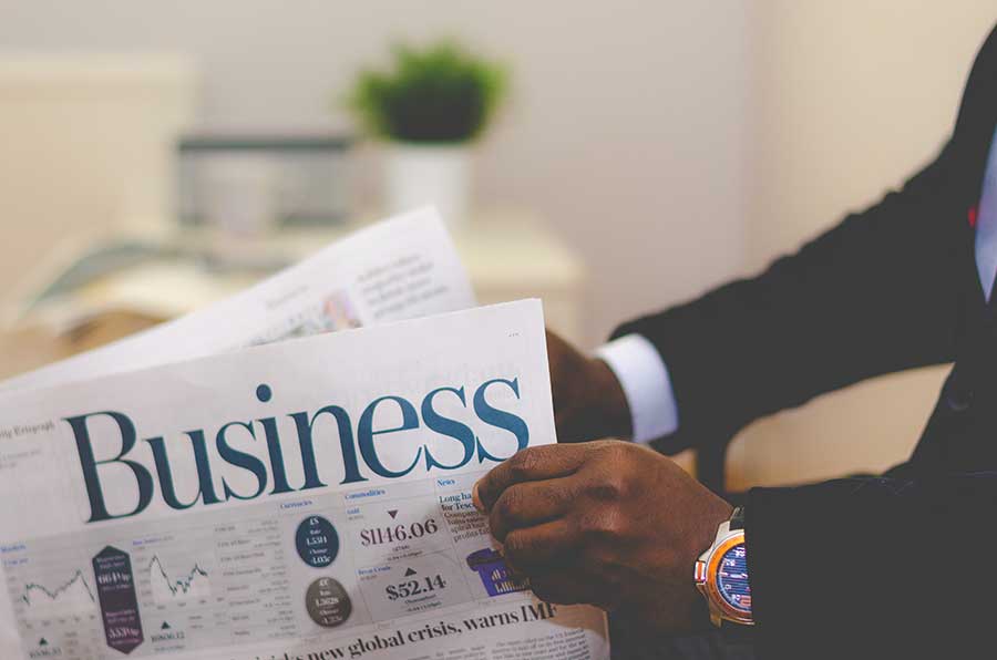 Man reading business newspaper in office