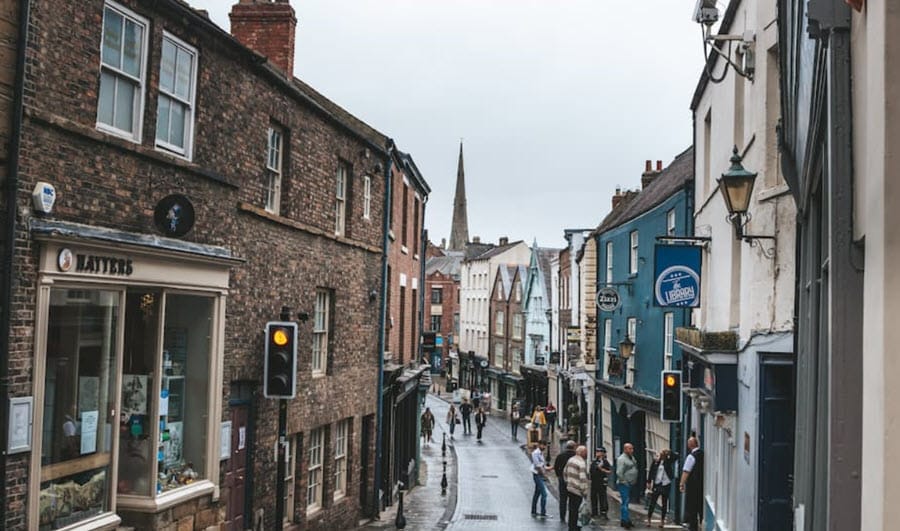 Charming British street with historic buildings and people.