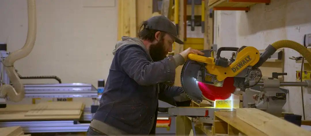 Carpenter using a circular saw in workshop.