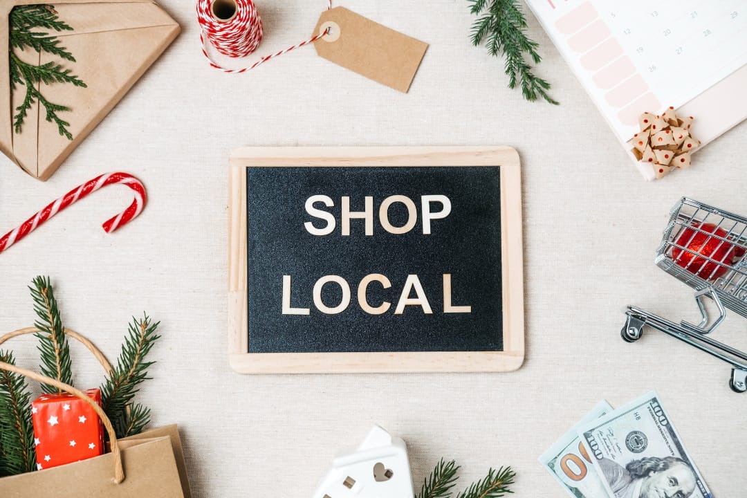 Shop local sign with holiday decorations.