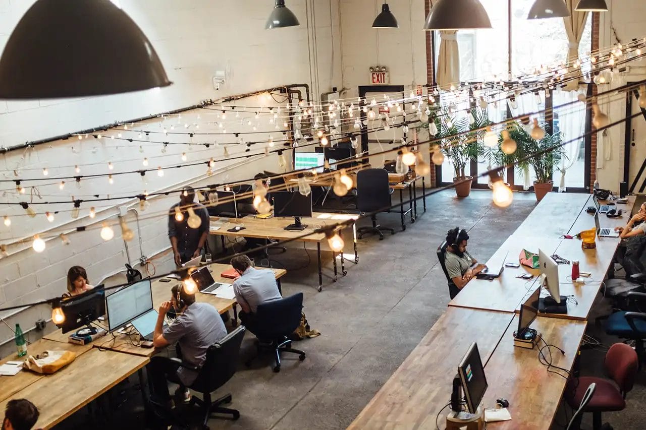 Modern coworking space with lights and desks.