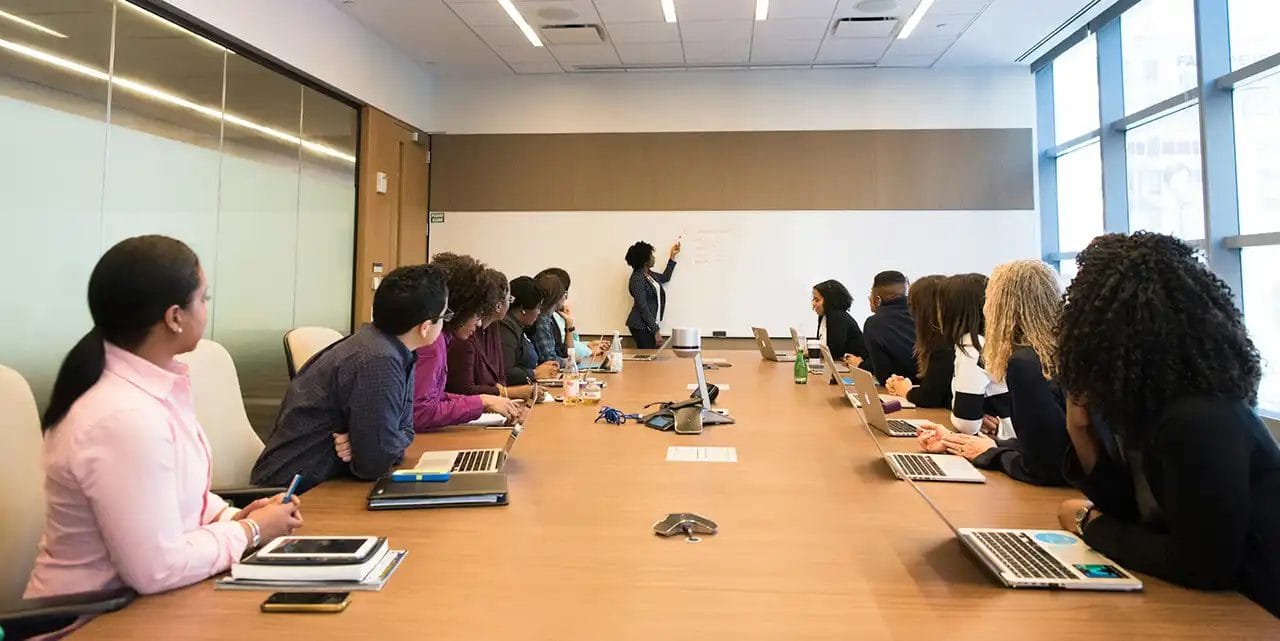 Team meeting in conference room with whiteboard presentation.