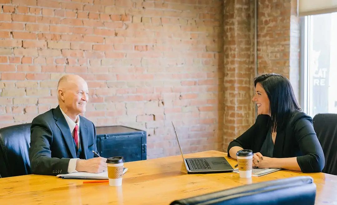 Colleagues having a meeting in a brick-walled room.