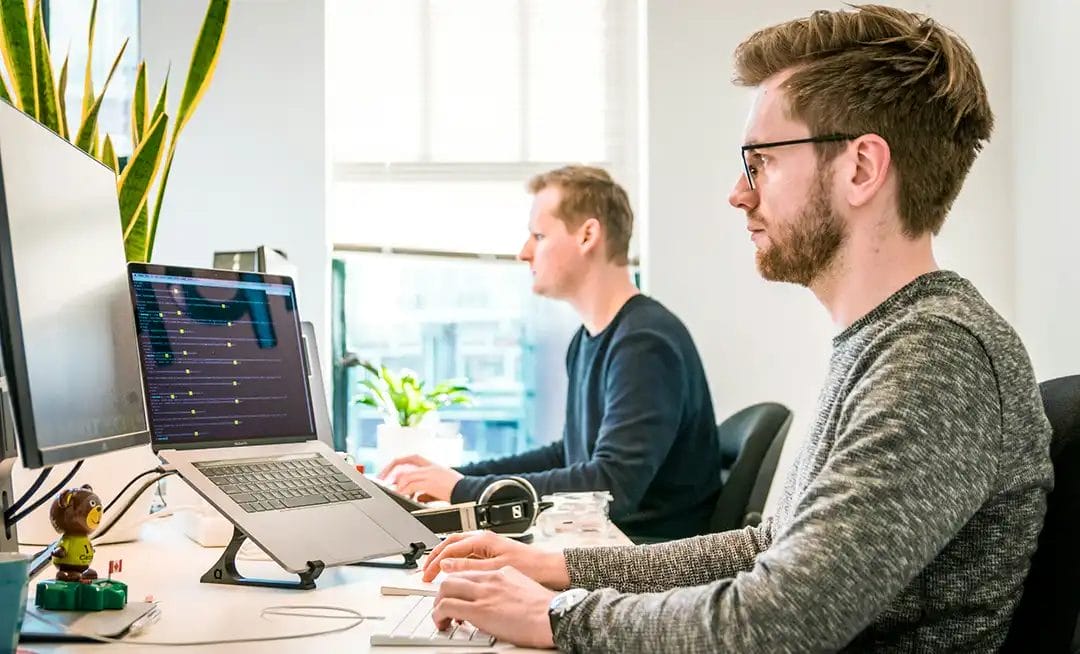 Two men working at computers in office