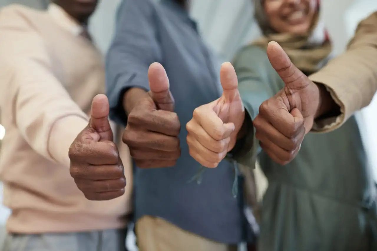 Diverse group giving thumbs up gesture