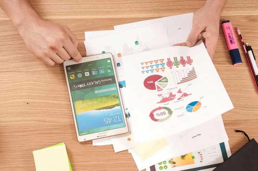 Tablet with colourful graphs and charts on desk.