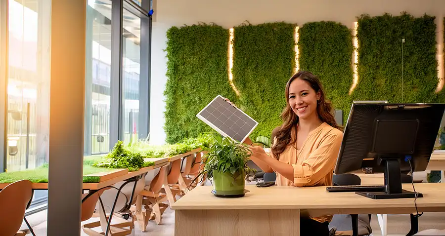 Woman with solar panel in green office space.