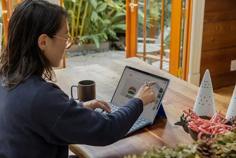 Person browsing online at home workspace