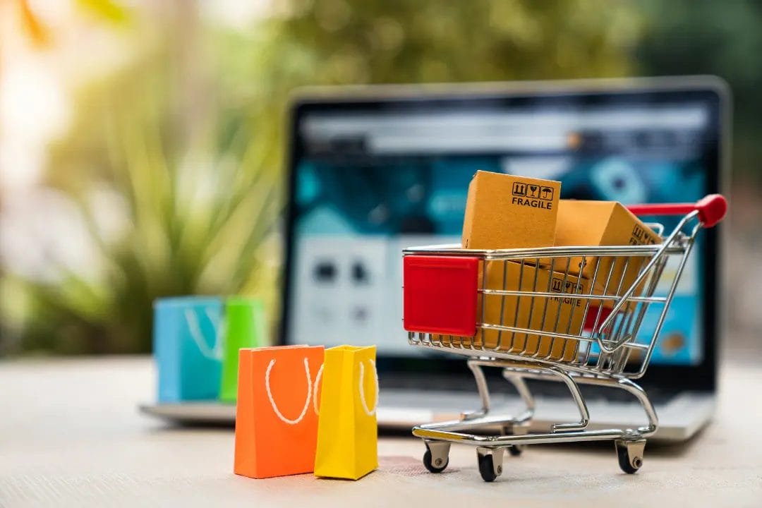 Shopping cart and bags in front of laptop