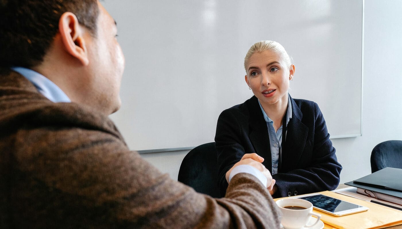 Business meeting handshake over coffee and tablets.