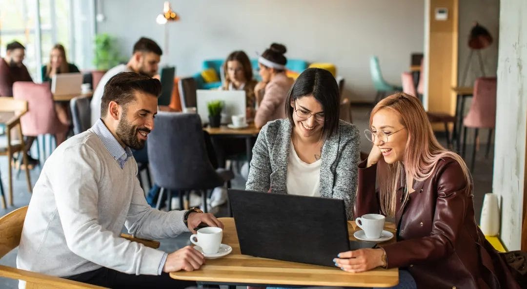 Group working in cafe with laptop and coffee.