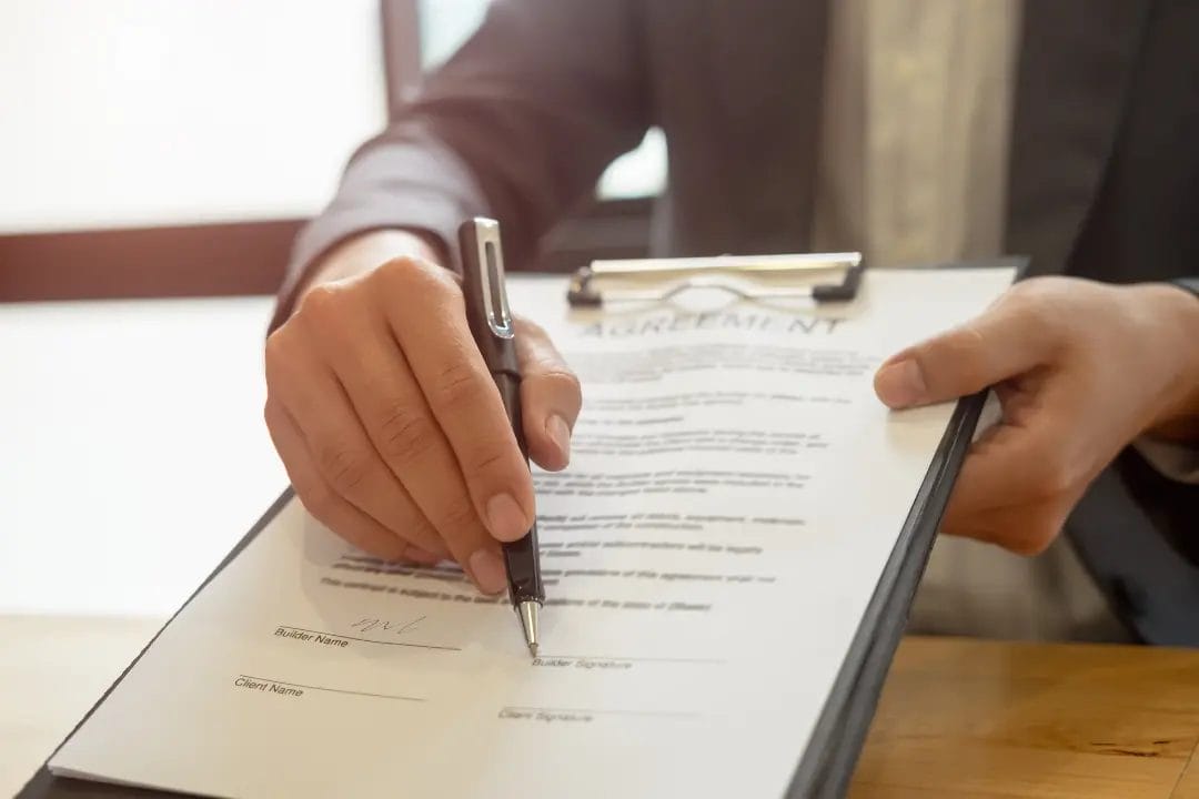 Person signing business agreement document.