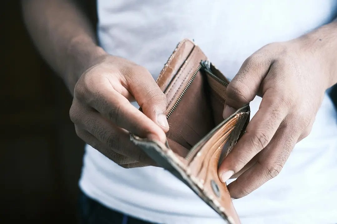 Person holding an empty brown wallet.