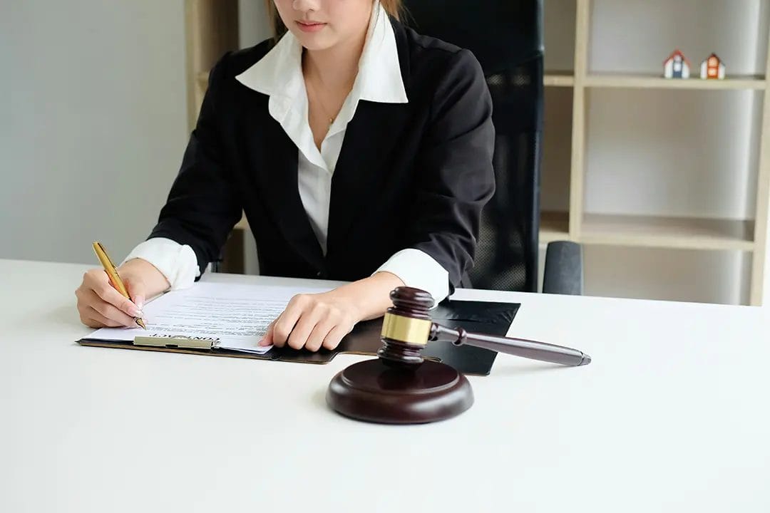 Lawyer writing at desk with gavel.