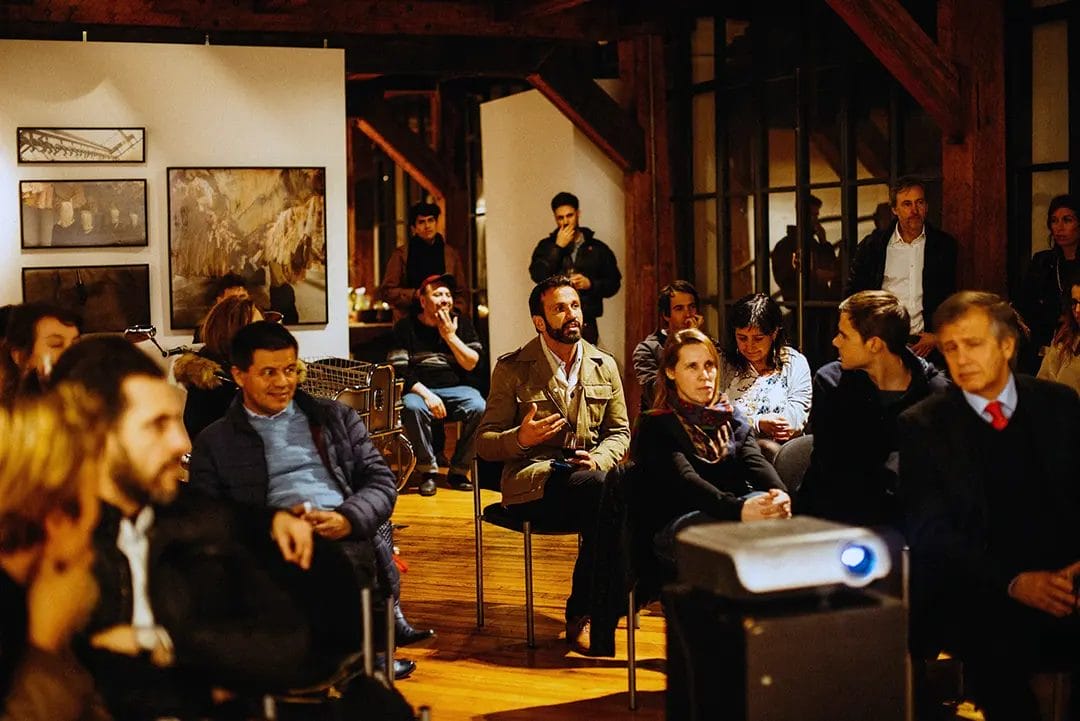 Audience attentively listening at an indoor event.