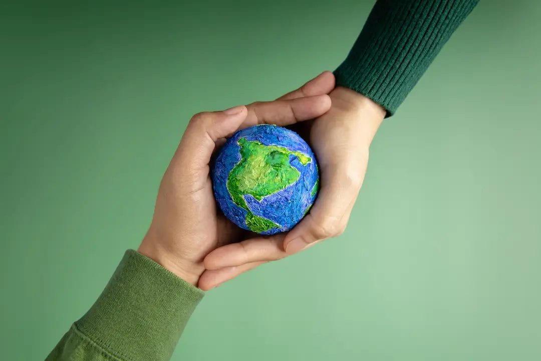 Hands holding a small Earth model