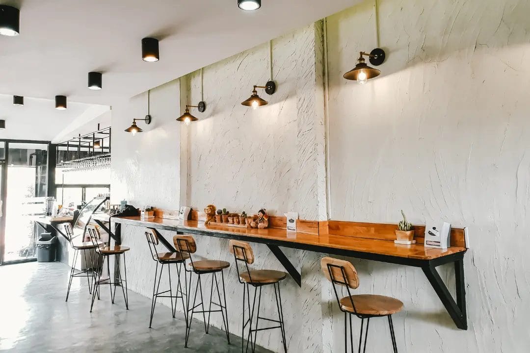 Chic café interior with bar stools and lighting.