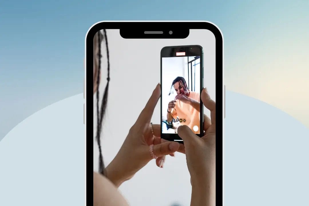 Person recording video on smartphone screen.